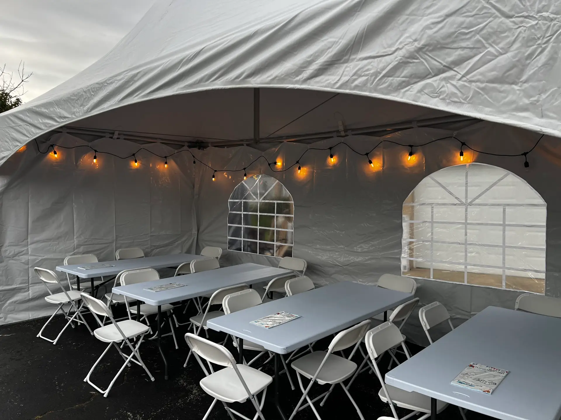 a white tent with tables and chairs inside