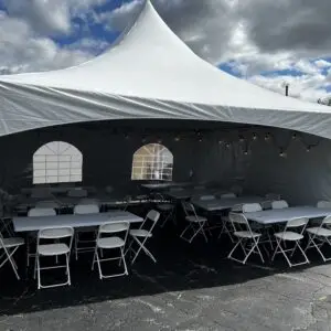 file and arrange empty tables and chairs inside the white tent