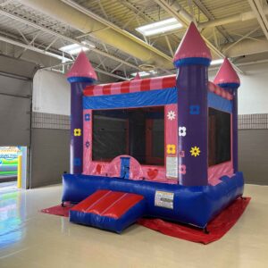 Princess-themed bounce castle with pink and purple towers set up indoors for a party or event.