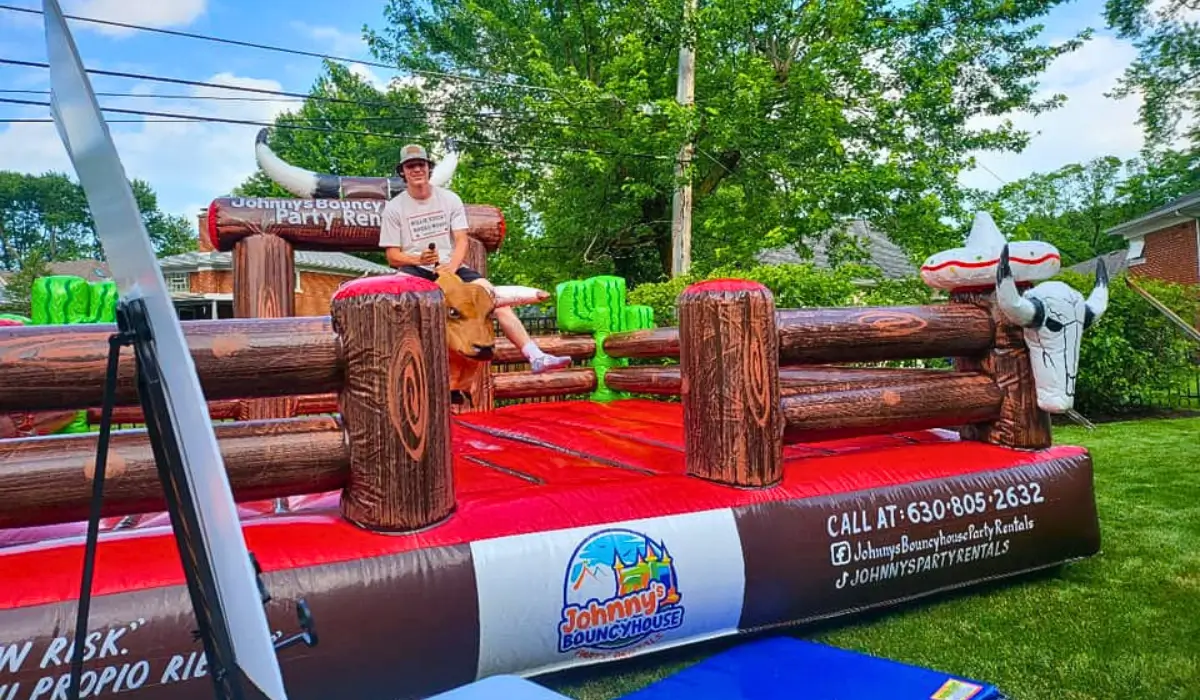 Guest riding a mechanical bull at Chicago Fall Festivals with Johnny’s Bouncy House and Party Rentals, showcasing a safe inflatable base and supervised setup.