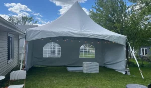 Outdoor tent rental tips image showing sidewall frame tent setup with lighting for cold-weather backyard event.